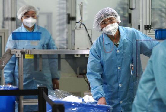 Workers produce KN95 face masks at a mask factory of 3M in Shanghai, east China, March 10, 2020. (Xinhua/Ren Long)