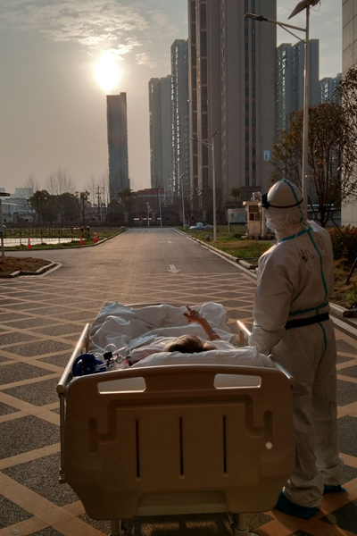 A coronavirus patient and doctor watch sunset outside a hospital in Wuhan, March 5, 2020. (Photo courtesy of Zhongshan Hospital affiliated to Fudan University)