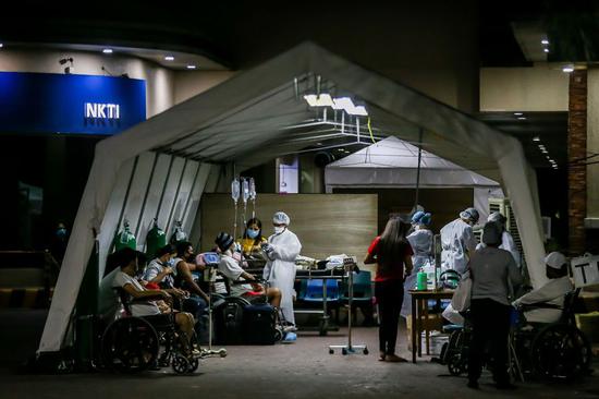 Medical workers screen patients for COVID-19 before allowing them into a hospital in Quezon City, the Philippines on March 28, 2020. (Xinhua/Rouelle Umali)
