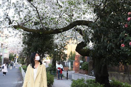 A woman walks on the street in Tokyo, Japan, March 22, 2020. (Xinhua/Du Xiaoyi)