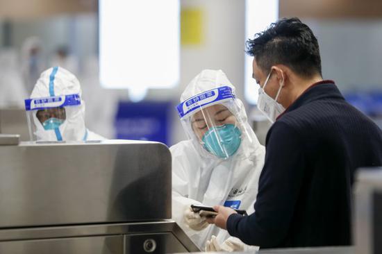 A staff member of the customs checks the health declaration information of a newly arrived inbound passenger in Chongqing, southwest China, March 29, 2020. (Xinhua/Huang Wei)