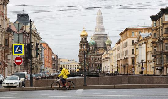 A delivery man wearing protective mask cycles in St. Petersburg, Russia, April 2, 2020. (Photo by Irina Motina/Xinhua)