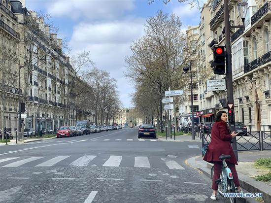 A woman is seen on an empty street in Paris, France, on April 2, 2020.  (Xinhua/Tang Ji)