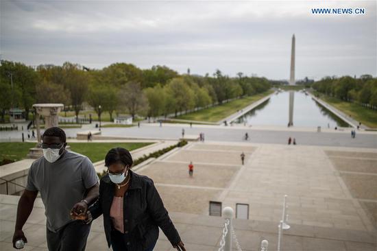 People wearing masks visit the Lincoln Memorial in Washington D.C., the United States on April 12, 2020. (Photo by Ting Shen/Xinhua)