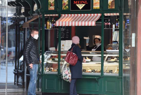 Customers visit a reopened snack bar at Graben street in Vienna, Austria on April 14, 2020. Some shops and businesses in Austria began to reopen from Tuesday. (Xinhua/Guo Chen)