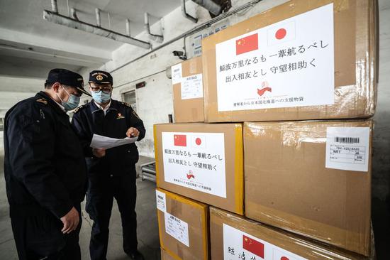 Customs officers check medical supplies donated to Ja TO GO WITH XINHUA HEADLINES OF APRIL 14, 2020. (Xinhua/Pan Yulong)