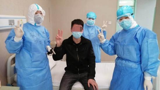 A 21-year-old patient (in black) poses with his doctors at Ankang Hospital in the city of Mudanjiang, Heilongjiang Province. The man, who wants to remain anonymous, is the first imported case to have recovered amid the current outbreak at the China-Russia border.（Photo/CGTN)