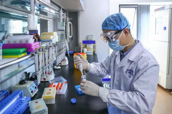 A staff member tests samples of the COVID-19 inactivated vaccine at a vaccine production plant of China National Pharmaceutical Group (Sinopharm) in Beijing, capital of China, April 11, 2020.