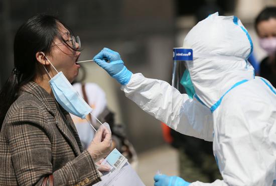 Health workers in Wuhan carry out physical examinations for employees at a company who return to work on April 9, 2020. (Photo by Zhou Guoqiang/for chinadaily.com.cn)