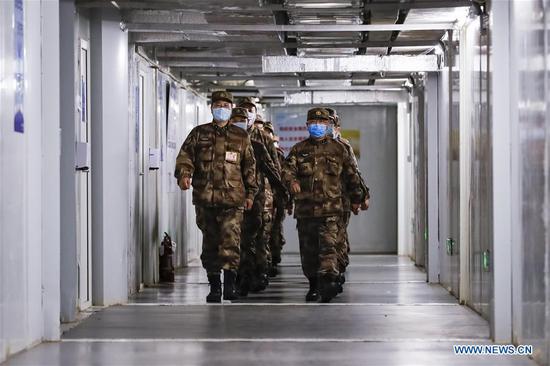 Military medics walk at the Huoshenshan Hospital in Wuhan, central China's Hubei Province, April 14, 2020. With the approval of Xi Jinping, chairman of the Central Military Commission, military medics who were dispatched to Hubei Province to assist with the treatment of COVID-19 patients have left the provincial capital city of Wuhan after completing their mission. The medics were transported by chartered flights and trains. (Xinhua/Shen Bohan)
