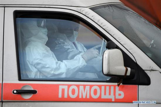 Medical workers wearing protective suits are seen in an ambulance in Kommunarka settlement outside Moscow, Russia, April 19, 2020. (Sputnik via Xinhua)