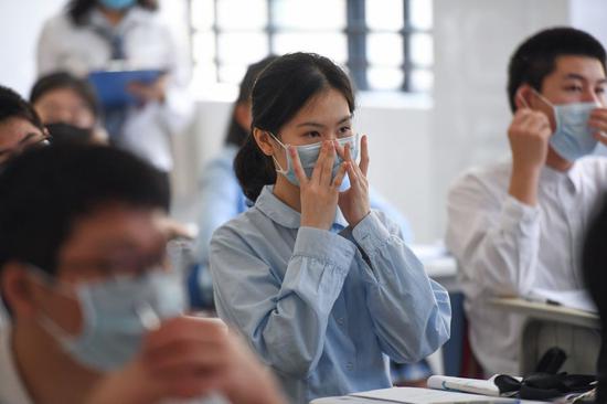 Students of grade 9 learn how to properly wear a face mask at Shenzhen Foreign Languages School in Shenzhen, south China's Guangdong Province, April 27, 2020. (Xinhua/Liang Xu)