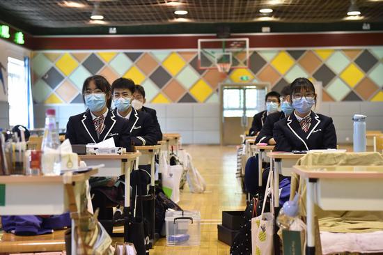 Students of a class are transferred to an indoor gymnasium to ensure the safe distance between seats at Guangqumen Middle School in Beijing, capital of China, April 27, 2020. Senior high schools in Beijing on Monday restarted classes for seniors, who will take the national college entrance exam on July 7-10. (Xinhua/Chen Zhonghao)