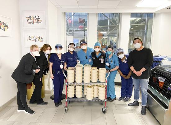 Health workers pose for a photo as Andrew Chu (1st R), operations and catering manager with Junzi Kitchen, delivers food for them in Mount Sinai Morningside hospital in New York, the United States, March 30, 2020. (Junzi Kitchen/Handout via Xinhua)