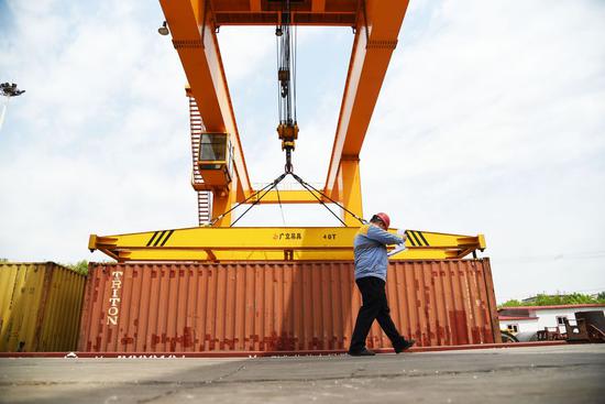 A staff member checks the loading work of medical supplies on a China-Europe freight train at Jinan South Railway Station in Jinan, east China's Shandong Province, April 26, 2020. (Xinhua/Wang Kai)