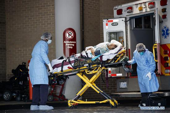 Medical workers carry a patient from an ambulance to George Washington University Hospital in Washington D.C., the United States, on April 27, 2020. (Photo by Ting Shen/Xinhua)