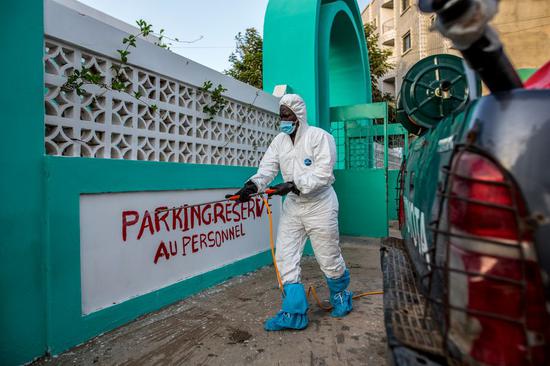 A health worker disinfects a building in Dakar, Senegal, April 1, 2020. (Photo by Eddy Peters/Xinhua)