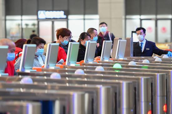 Passengers pass the automatic ticket gate at the Changsha station of the Changsha-Zhuzhou-Xiangtan Intercity Railway in Changsha, central China's Hunan Province, April 21, 2020. (Xinhua/Chen Zeguo)