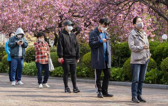 Voters stand in line with a social distance as they enter a polling station in Seoul, South Korea, April 15, 2020. (Photo by Lee Sang-ho/Xinhua)