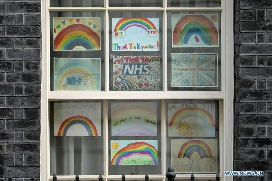 Photo taken on April 29, 2020 shows pictures thanking the National Health Service (NHS) on the windows of 10 Downing street in London, Britain. (Photo by Tim Ireland/Xinhua)

