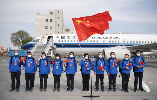 Members of a medical team assigned to Kyrgyzstan to help with the battle against the COVID-19 pandemic pose for a group photo upon their arrival in Urumqi, northwest China's Xinjiang Uygur Autonomous Region, April 27, 2020. (Xinhua/Sadat)
