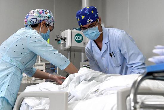 Nurses Liu Guangyao (R) and Qiao Bing take care of a patient at an ICU ward of the Third People's Hospital of Henan in Zhengzhou, central China's Henan Province, April 26, 2020. Liu Guangyao and Qiao Bing are both the hospital's ICU nurses, who are a pair of lovers born in 1990s. (Xinhua/Li An)