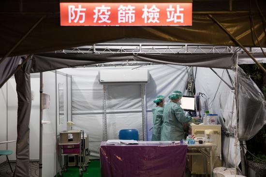 Medical workers are busy at the screening station for possible COVID-19 cases at a hospital in Taipei, southeast China's Taiwan, March 30, 2020. (Xinhua/Jin Liwang)