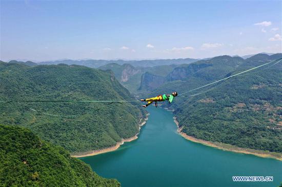 Man balances on highline at outdoor sports base in Hubei