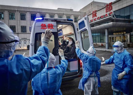 Members of the first group of imported COVID-19 patients diagnosed at Suifenhe port in Northeast China's Heilongjiang province who were cured and discharged from the hospital on April 21, 2020 wave goodbye to medics. (Photo by Pan Songgang/For chinadaily.com.cn)