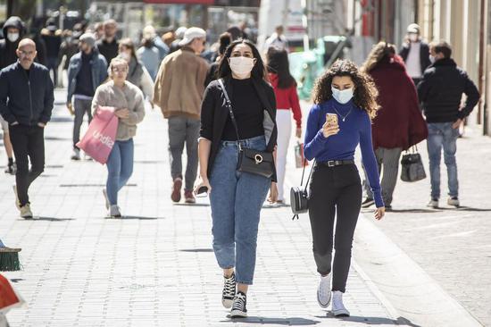 People wearing masks walk on the street in Lille, north France, May 11, 2020. (Photo by Sebastien Courdji/Xinhua)