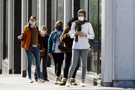 People wait outside a grocery store in Washington D.C., the United States on May 10, 2020. (Photo by Ting Shen/Xinhua)