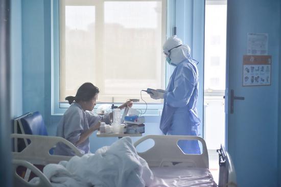 Nurse Gao Qi checks health condition for a patient at Beijing Ditan Hospital in Beijing, capital of China, May 11, 2020. Beijing Ditan Hospital is one of the capital's designated hospitals for treating COVID-19 patients. (Xinhua/Peng Ziyang)