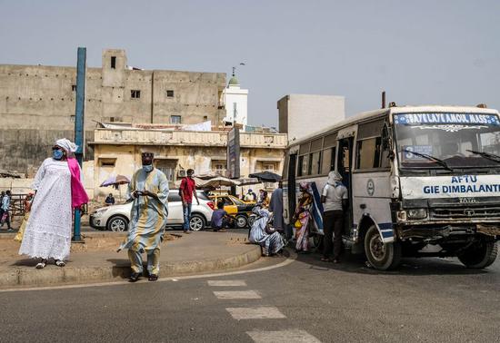 People wearing face masks wait for public transport in Dakar, Senegal, May 12, 2020. (Xinhua/Eddy Peters)