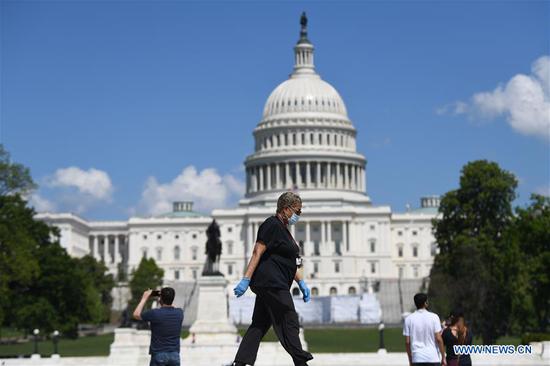 A woman wearing a face mask walks past the U.S. Capitol building in Washington D.C., the United States, May 15, 2020. (Xinhua/Liu Jie)