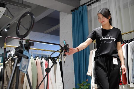 A model promotes clothes online in Nanchang, East China's Jiangxi province, on March 25, 2020. (Photo/Xinhua)