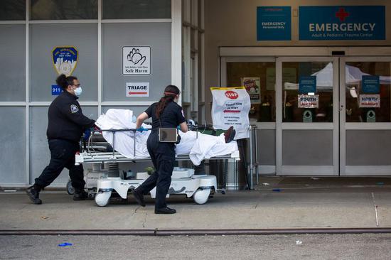 Healthcare workers bring a patient into the emergency room at Maimonides Medical Center during the coronavirus pandemic in the Brooklyn borough in New York, the United States, April 8, 2020. (Photo by Michael Nagle/Xinhua)