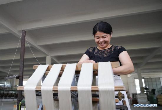 An employee works at a silk company in Le'an County, east China's Jiangxi Province, on May 19, 2020. In recent years, Le'an has been making efforts to promote its sericulture program and planted more than 1,053 hectares of mulberry trees. About 1,400 impoverished households in the county increased their income through the program and shook off poverty. (Xinhua/Hu Chenhuan)