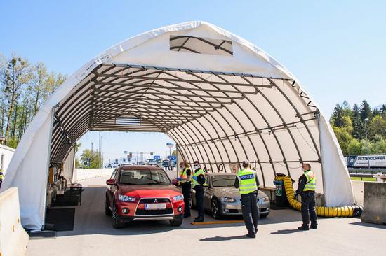 Police officers wearing face masks work at a checkpoint on the border between Germany and Austria in Bad Reichenhall, southern Germany, on April 23, 2020. (Photo by Kevin Voigt/Xinhua)