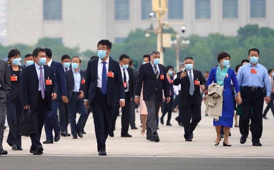 Members of the 13th National Committee of the Chinese People's Political Consultative Conference (CPPCC) walk towards the Great Hall of the People for the opening meeting of the third session of the 13th CPPCC National Committee in Beijing, capital of China, May 21, 2020. (Xinhua/Cai Yang)