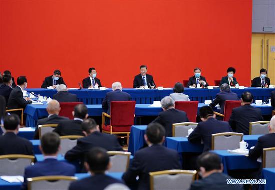 Chinese President Xi Jinping, also general secretary of the Communist Party of China (CPC) Central Committee and chairman of the Central Military Commission, visits national political advisors from the economic sector attending a joint panel discussion at the third session of the 13th National Committee of the Chinese People's Political Consultative Conference (CPPCC) in Beijing, capital of China, May 23, 2020. Xi joined them in the discussion and heard their comments and suggestions. Wang Yang, a member of the Standing Committee of the Political Bureau of the CPC Central Committee and chairman of the CPPCC National Committee, also attended the discussion. (Xinhua/Xie Huanchi)