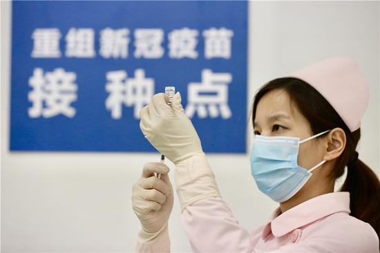 A medical worker extracts the recombinant novel coronavirus (COVID-19) vaccine into a syringe in Wuhan, Central China's Hubei province, on March 24, 2020. The first batch of 108 volunteers received inoculations after a clinical trial of the novel coronavirus vaccine in China kicked off on March 16.(Photo by Zhu Xingxin/chinadaily.com.cn)