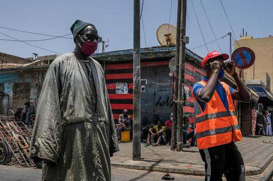 Photo taken on May 23, 2020 shows people wearing masks at public places in Dakar, Senegal. (Photo by Eddy Peters/Xinhua)