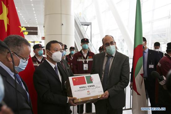 Chinese Ambassador to Algeria Li Lianhe (2nd L) and Mohamed El Hadj, director general of the Health Department at Algeria's Health Ministry, take part in the handover ceremony of medical supplies at Algiers International Airport in Algiers, Algeria, May 14, 2020. A team of Chinese medical experts on Thursday arrived in Algeria to help the North African country fight the COVID-19 pandemic. (Xinhua)