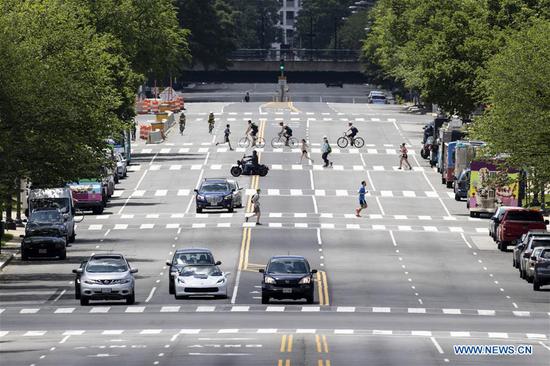 People cross the street on the National Mall in Washington D.C., the United States on May 23, 2020.  (Photo by Ting Shen/Xinhua)