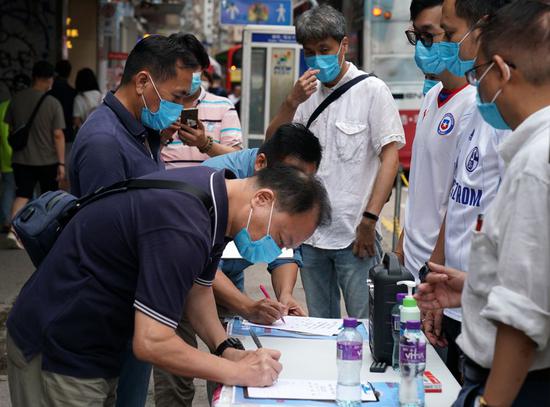 Residents sign in a street campaign in support of national security legislation for Hong Kong Special Administrative Region (HKSAR) in Hong Kong, south China, May 23, 2020. (Xinhua/Li Gang)