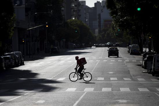 A man rides across an empty street in Buenos Aires, Argentina, April 8, 2020. (Photo by Martin Zabala/Xinhua)
