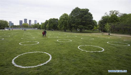 Toronto paints circles on grass at Trinity Bellwoods Park to encourage people in physical distancing