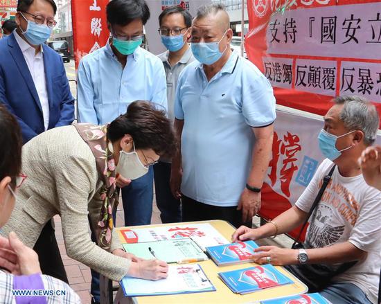Chief Executive of the Hong Kong Special Administrative Region (HKSAR) Carrie Lam signs a petition in support of the national security legislation as she visits a street stand in Hong Kong, south China, May 28, 2020.  (Xinhua)