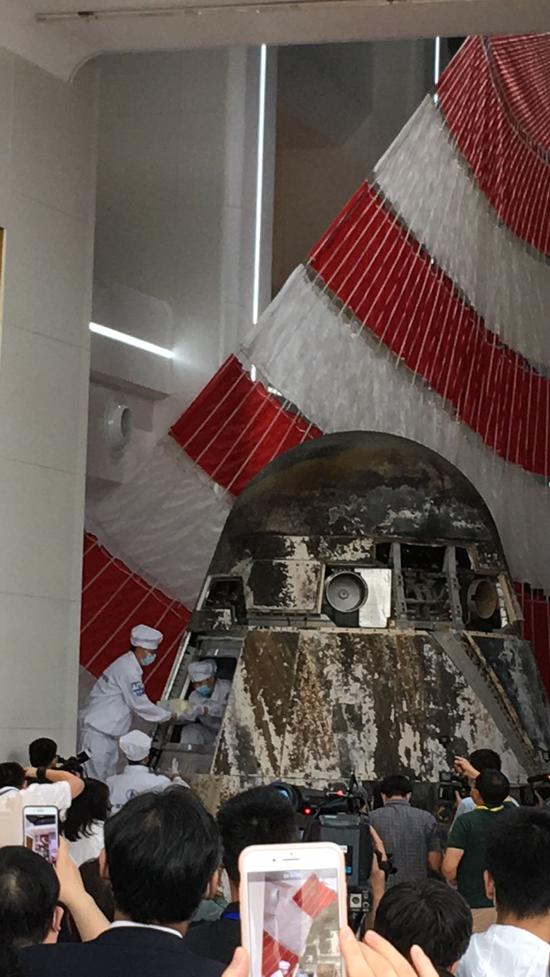 Chinese engineers open the re-entry module of the prototype of China's new-generation manned spacecraft that returned to Earth earlier this month, distributing items inside it to their owners, May 29, 2020. (Photo by Zhao Lei/chinadaily.com.cn)