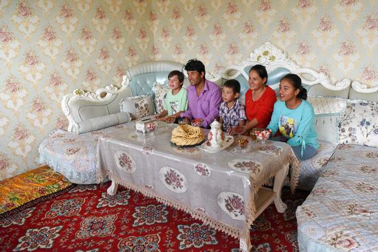 Renagul Karman (2nd R) and her family watch television shows at home in Tongan Township of Zepu County, Kashgar, northwest China's Xinjiang Uygur Autonomous Region, Aug. 15, 2019. (Xinhua/Ding Lei)